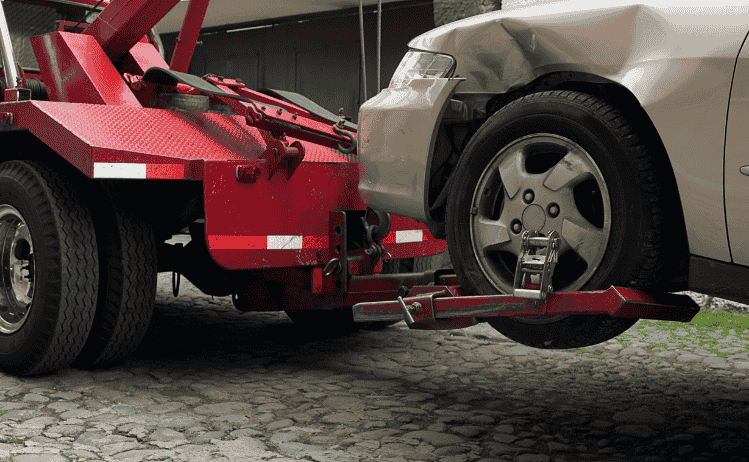 Tow truck removing a severely damaged, abandoned car with a hook in Polk County – Lakeland Car Towing & Roadside Assistance wrecking service
